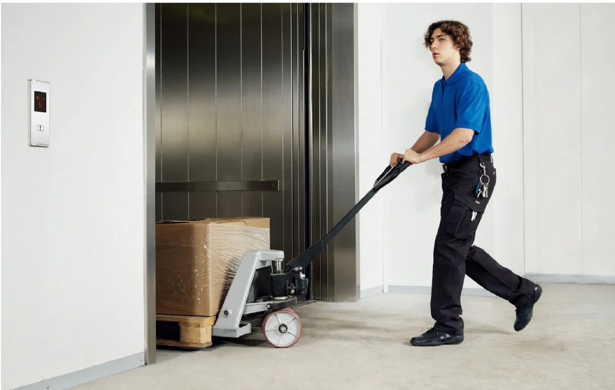Freight elevator carrying goods with a pallet truck